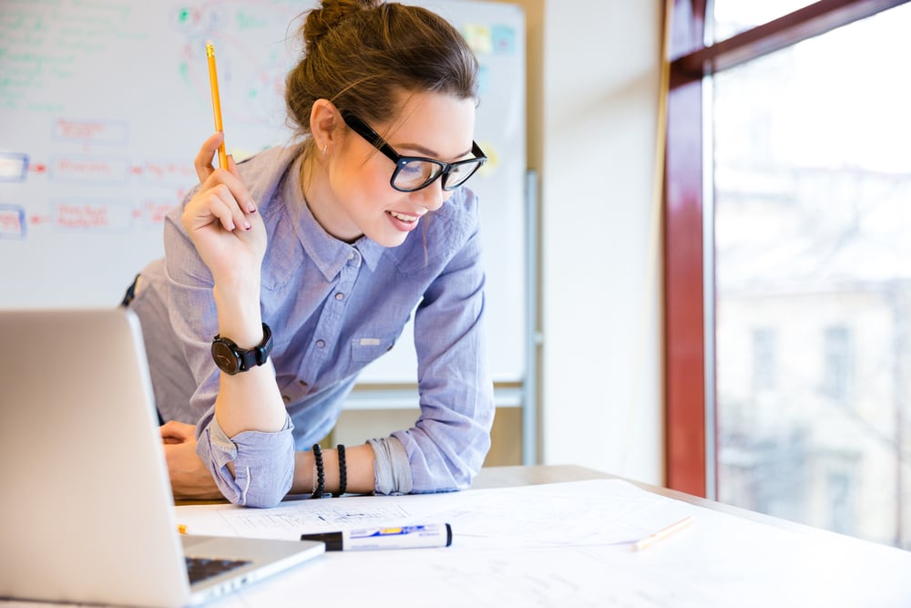 Businesswoman using FreshBooks software within her creative agency.