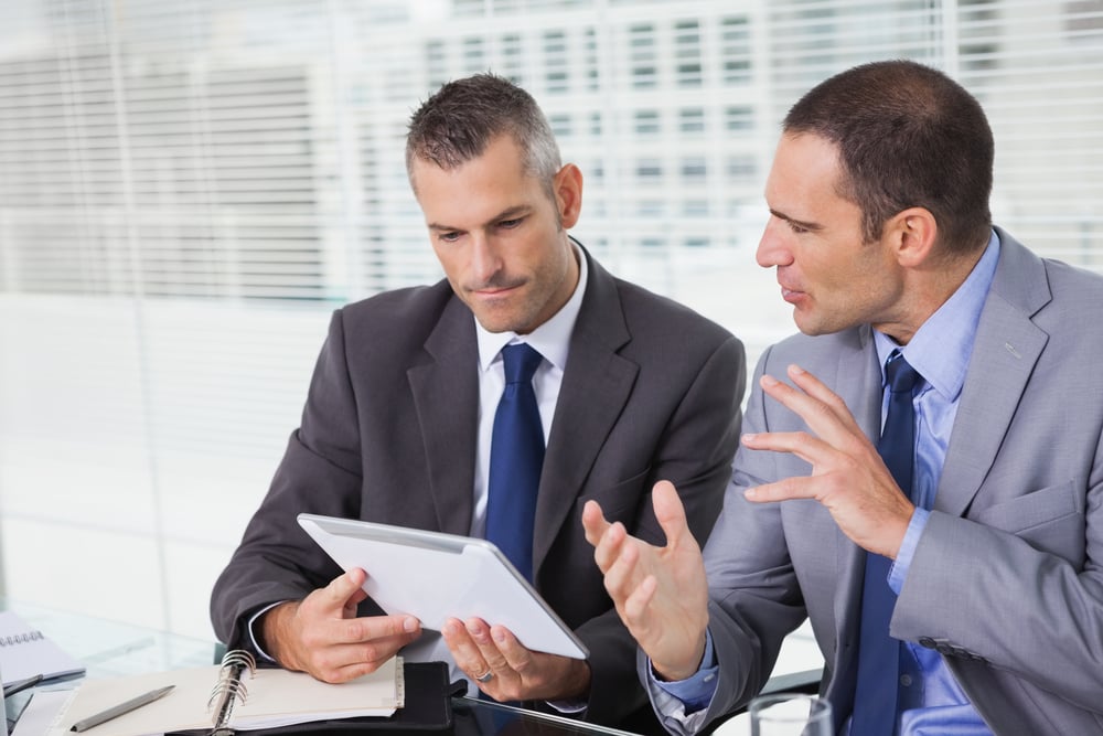 Businessmen recognizing QuickBooks is inadequate for their growing business.