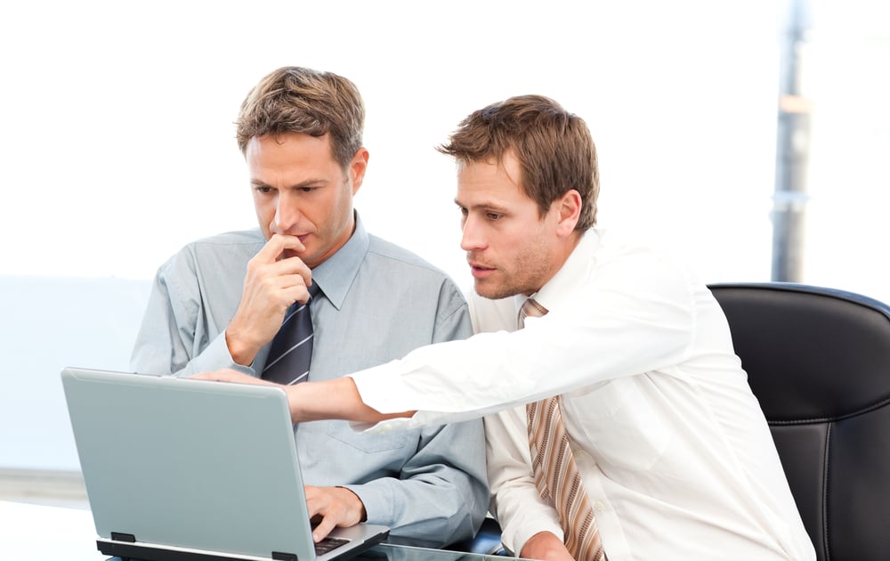 Two businessmen analyzing data produced from their Shopify eCommerce platform.